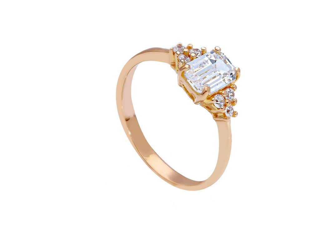 18k rose gold solitaire trilogy engagement ring with 6x4mm emerald cut zirconia.